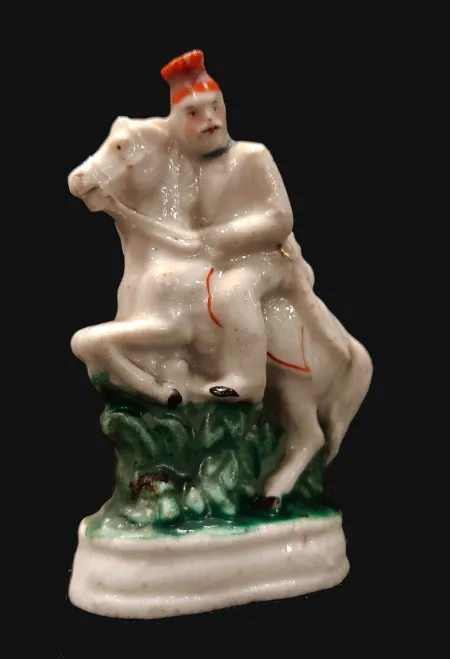 A Porcelain Figure of a Boy  Riding a Horse
